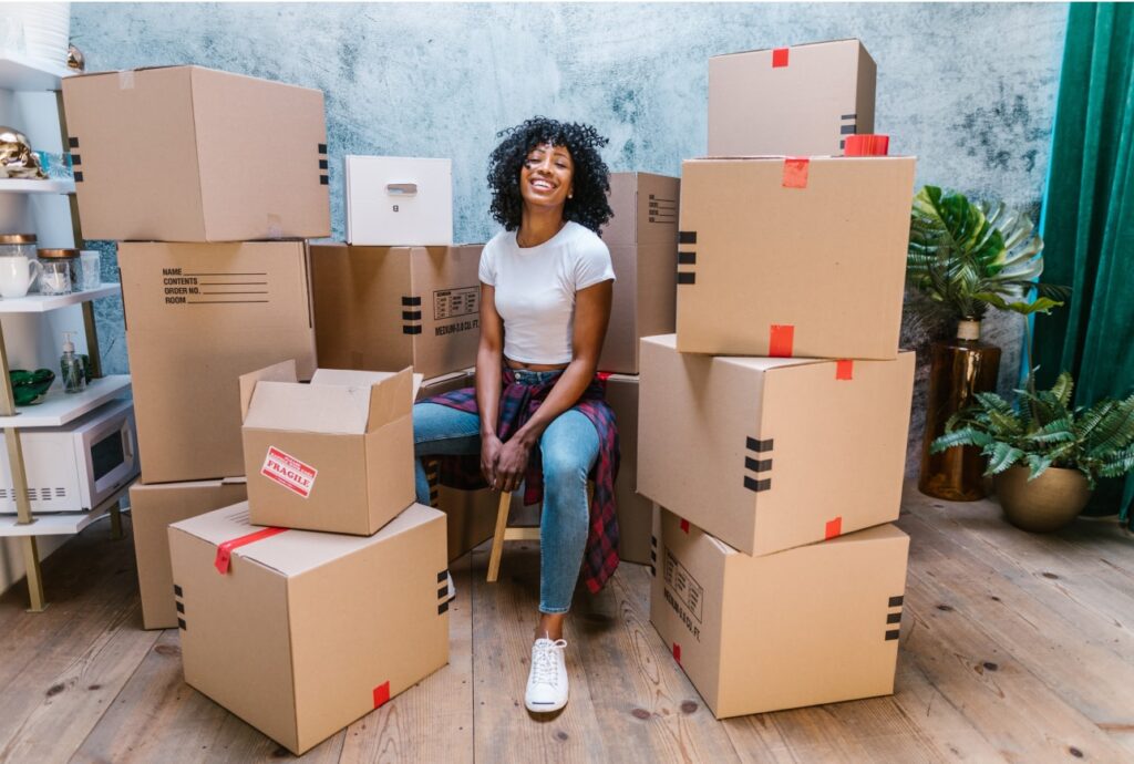 A woman sitting in the middle of the stacks of boxes.